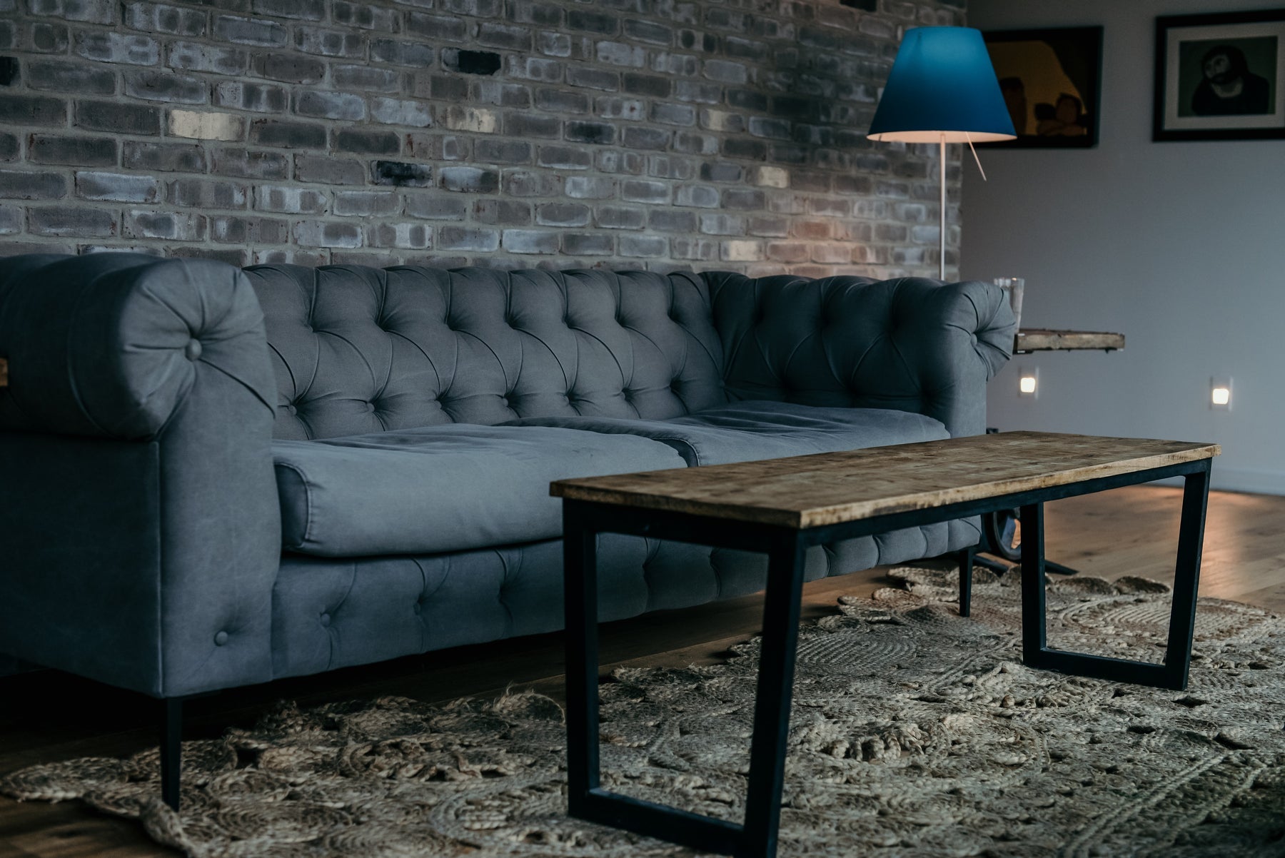 Large grey sofa by brick wall